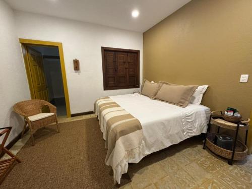 a bedroom with a bed and a chair in it at Hotel Mandalay 1941 in Pereira