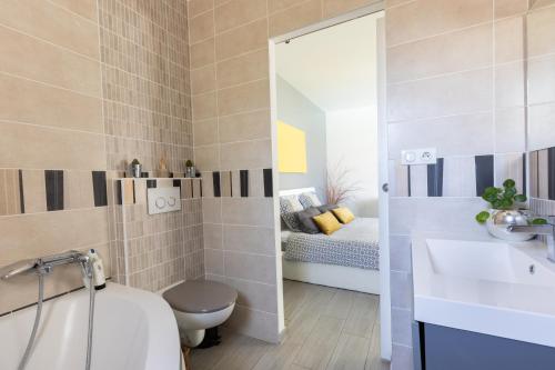 a bathroom with a toilet and a sink and a mirror at Olympe de Provence in Caromb