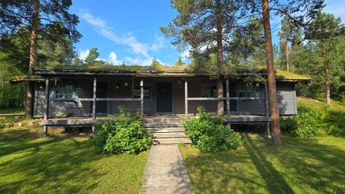a wooden house with a porch in the grass at ONGA Boutique Lodge in Alta