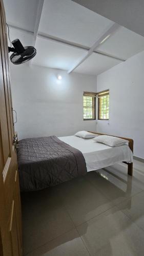 a white room with a bed and two windows at Adan Paradise Riverview Homestay in Attappādi