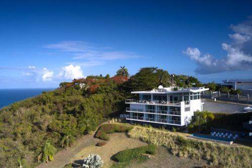 an aerial view of a building on a hill next to the ocean at Happy Days Villa C in Fajardo