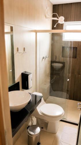 a bathroom with a sink and a toilet and a shower at Nura Pousada in Maragogi