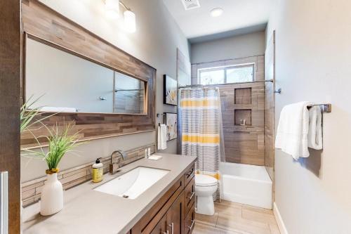 a bathroom with a sink and a toilet and a mirror at Bright & Spacious Family Home with Firepit, Lake Views, Furnished Deck, Free WiFi in Lago Vista