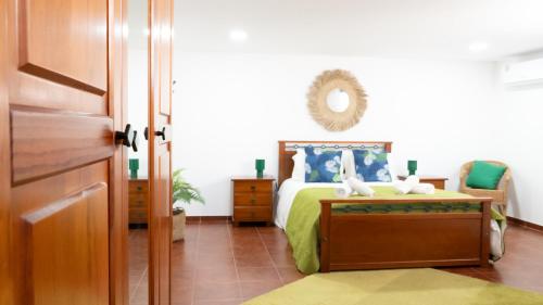 a bedroom with a bed and a mirror on the wall at Casinha Alice in Nazaré