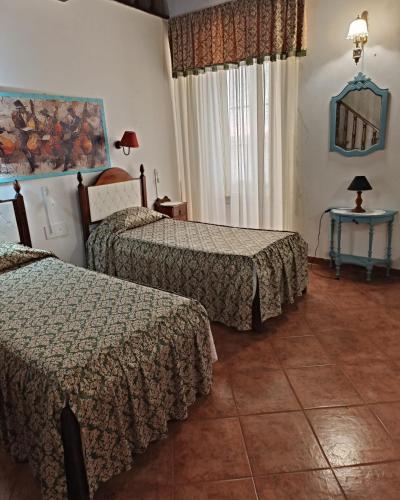 a hotel room with two beds and a table at Casa Galache in Vila Franca de Xira