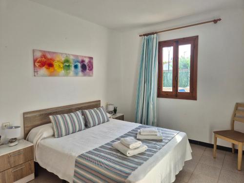 a bedroom with a bed with towels on it at Villa familiar con piscina privada en Calan Blanes in Cala en Blanes