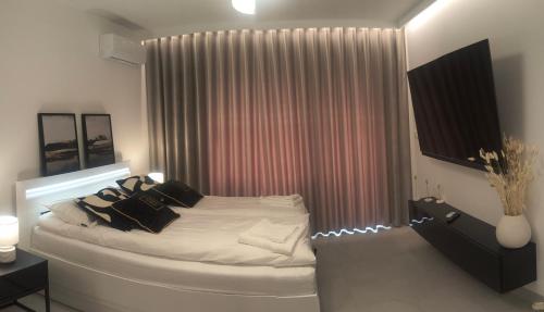 a bedroom with a white bed with black pillows at Mazury Glam Studio in Giżycko