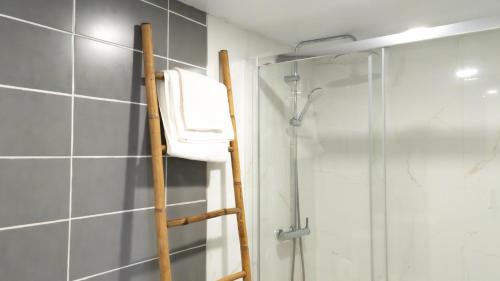 a bathroom with a shower with a towel hanging on a ladder at Casinha Alice in Nazaré