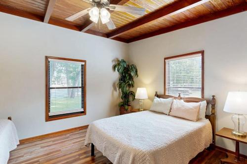 a bedroom with a bed and a ceiling fan at Classic Lakefront Cottage with Private Dock, Lovely Lake View, Backyard & WiFi in Kingsland