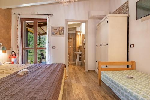 a bedroom with a bed and a door to a bathroom at Tra Cielo e Mare Rooms Rio Marina in Rio nellʼElba