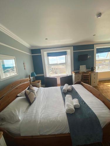 a bedroom with a large bed with towels on it at The Top House Inn in Lizard