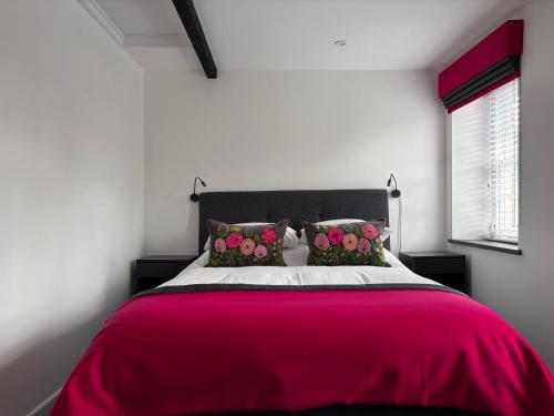 a bedroom with a large bed with a red blanket at 10 Crickhowell Cottages, Standard Street, Central Crickhowell in Crickhowell