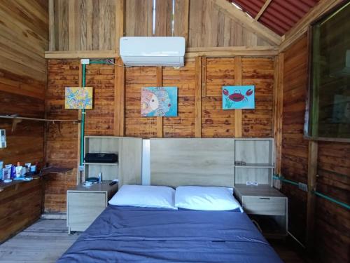 a bedroom with a bed in a wooden room at Palmar Beach Cabañas - Bahía Rada in Moñitos