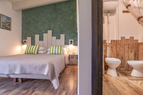 a bedroom with a bed and a bathroom with a toilet at Tra Cielo e Mare Rooms Rio Marina in Rio nellʼElba