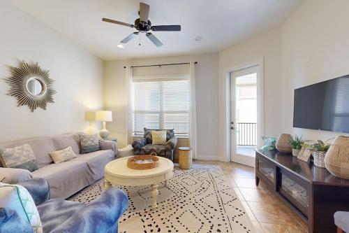 a living room with a couch and a tv at Hill Country Corner Condo at The Waters - Central AC, Lake Views & Pool in Horseshoe Bay