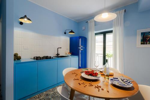 a kitchen with blue cabinets and a wooden table at Case Borgo Vacanze in Letojanni