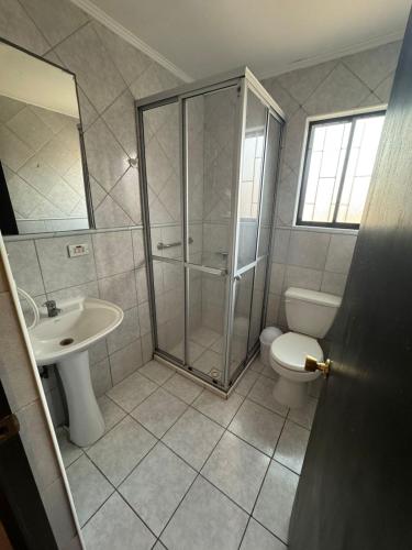 a bathroom with a shower and a toilet and a sink at Hostal Almendral in San Felipe