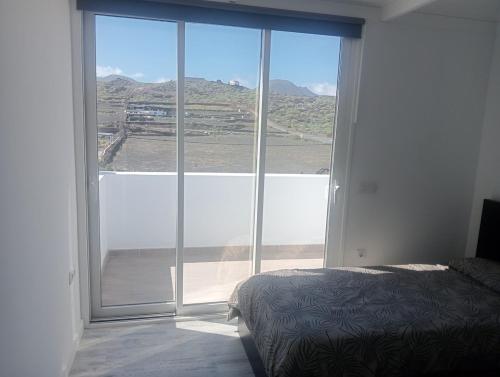 a bedroom with a large window with a view at Volcán de la Corona House in Punta Mujeres