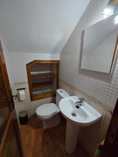 a bathroom with a toilet and a sink and a mirror at Volcán de la Corona House in Punta Mujeres