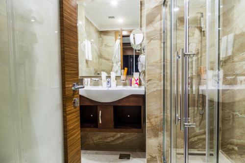 
a bathroom with a shower, sink, and mirror at Harir Palace Hotel in Amman
