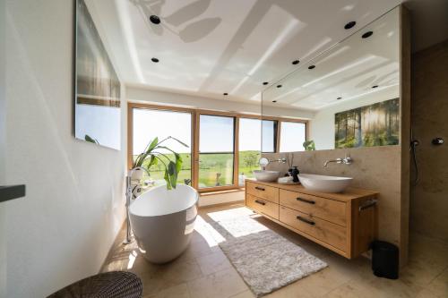 a bathroom with two sinks and a large window at Eifelvilla Weber in Arenrath