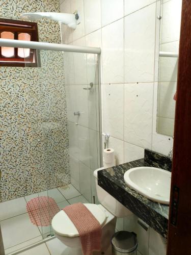 a bathroom with a shower and a toilet and a sink at Casas Bela da Chapada in Lençóis