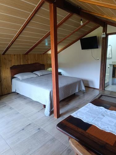 a bedroom with two beds and a flat screen tv at Hospedagem Na Rota do Enxaimel - Andar Térreo ou Superior - Alles Acer in Pomerode