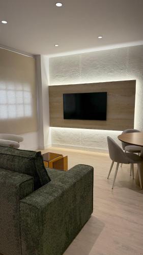 a living room with a couch and a flat screen tv at Palacios Centro - El Puerto in El Puerto de Santa María