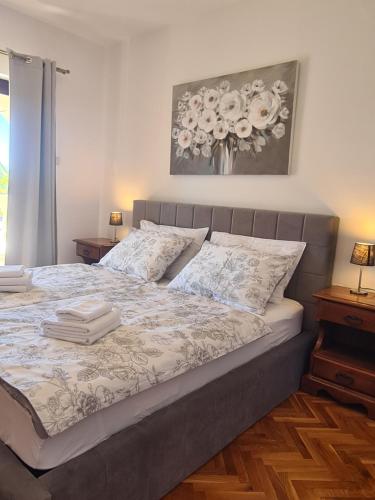 a bedroom with a bed with a vase of flowers on the wall at Villa Rea in Malinska