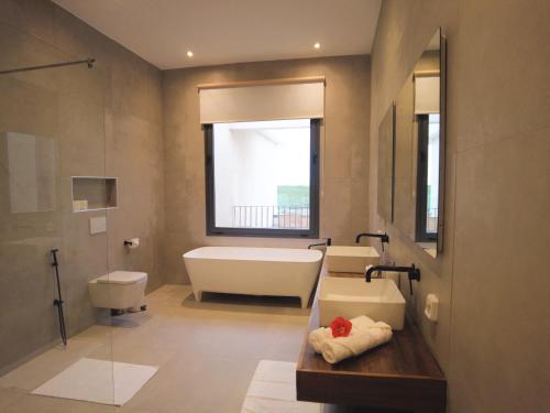 a bathroom with a tub and a toilet and a sink at Villa Tarrafal in Somone