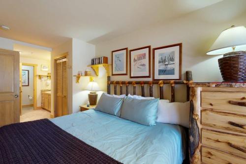 a bedroom with a bed with a wooden headboard at Copper Springs Lodge 101 in Copper Mountain