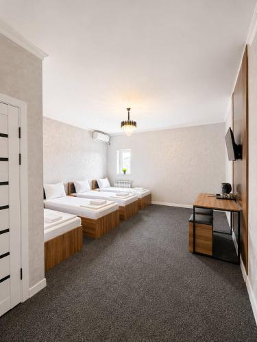 a hotel room with two beds and a tv at Ameli Plaza Hotel Tashkent in Yakkasaray