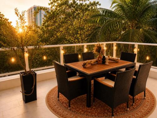 a wooden table and chairs on a balcony with a table and lights at Oasis on Monroe Aparthotel in Hollywood