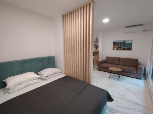 a bedroom with a large bed and a couch at Shark Herceg Novi in Meljine