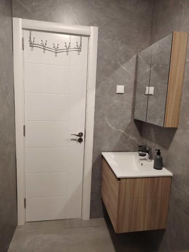 a bathroom with a sink and a white door at Shark Herceg Novi in Meljine