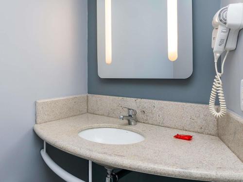 a bathroom counter with a sink and a phone at ibis Chapeco in Chapecó