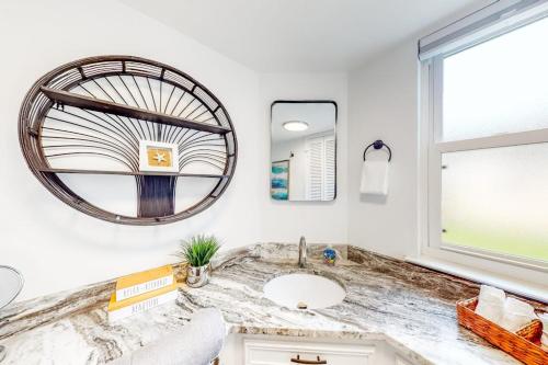 a bathroom with a sink and a large mirror at Peaceful Mid-Century Escape with Screened Porch & Lake Access in Lago Vista