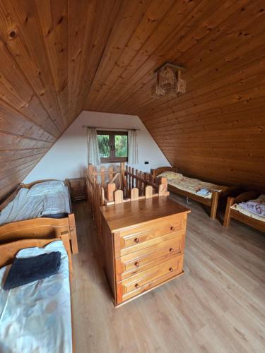 a bedroom with two beds and a dresser in a attic at Hacjenda in Redło