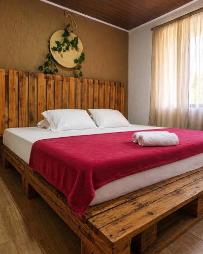 a large wooden bed with a red blanket on it at Complejo Campestre Salome Cabañas & Hotel in Calima