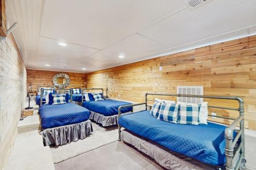 three beds in a room with wooden walls at Opulent Waterfront Home with Dock, Firepit & Stunning River View in Burnet
