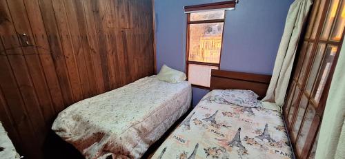 a small room with two beds and a window at Cabañas Caprumadp in Quintero