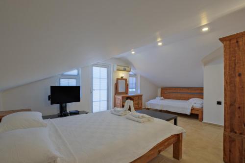 a large bedroom with a bed and a tv at Villa Ahad in Fethiye