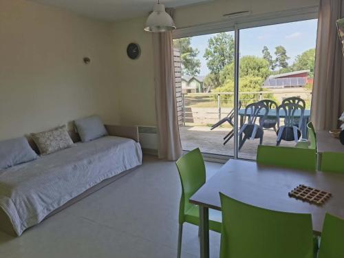a bedroom with a bed and a table and chairs at cottage poussin 12 picine lave linge in Chaveignes