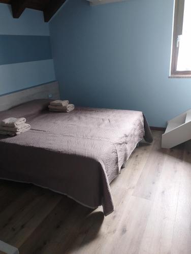 a bedroom with a bed and a wooden floor at Casa All'Angelo in Piovene Rocchette