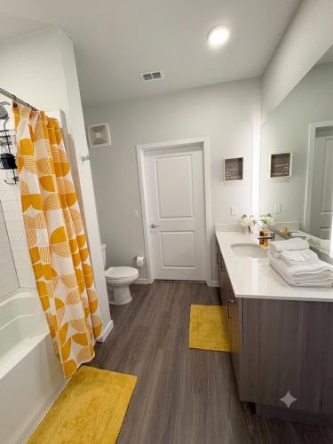 a bathroom with a tub and a sink and a toilet at Coastal Life at Aqua in Bradenton