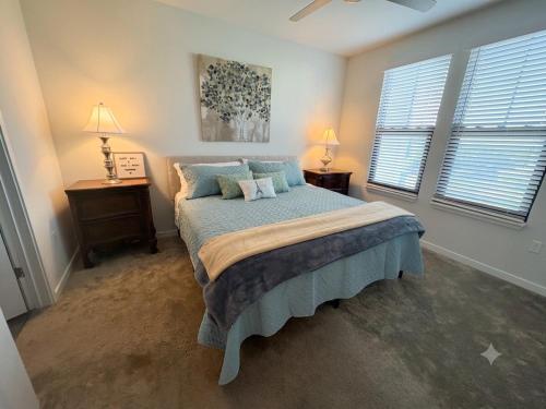 a bedroom with a bed and two windows at Coastal Life at Aqua in Bradenton
