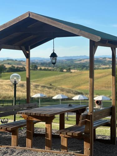 a wooden picnic table with awning and a lamp at Wine Resort Colsereno in Montalcino