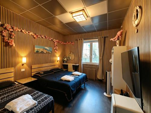a hotel room with two beds and a television at BED & BREAKFAST SAKURA in Milan