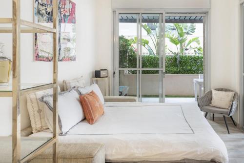 a bedroom with a bed and a large window at Allenby 36 Bauhaus Residence 5 Stars in Tel Aviv