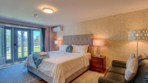 a bedroom with a bed and a couch and a chair at Lee's Ocean Peek B & B in Stratford